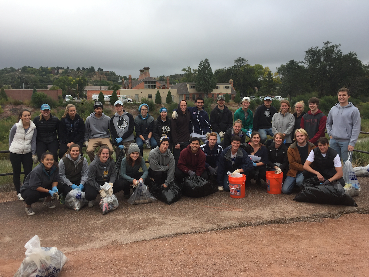 A college class posing for a group photo after doing some local clean up